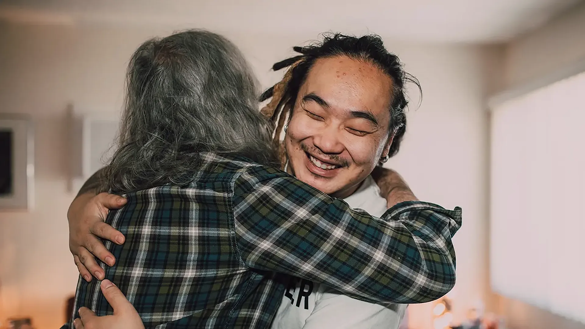 Young male carer hugging a resident